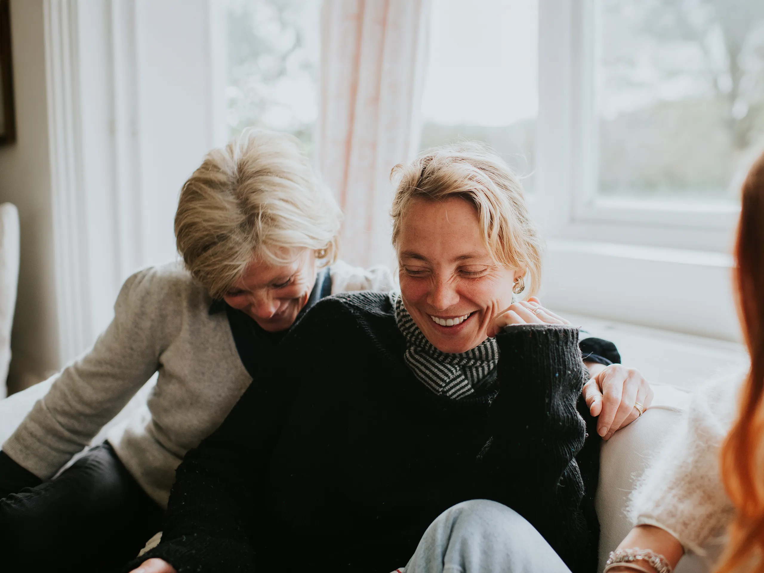 Twee lachende vrouwen op een bank