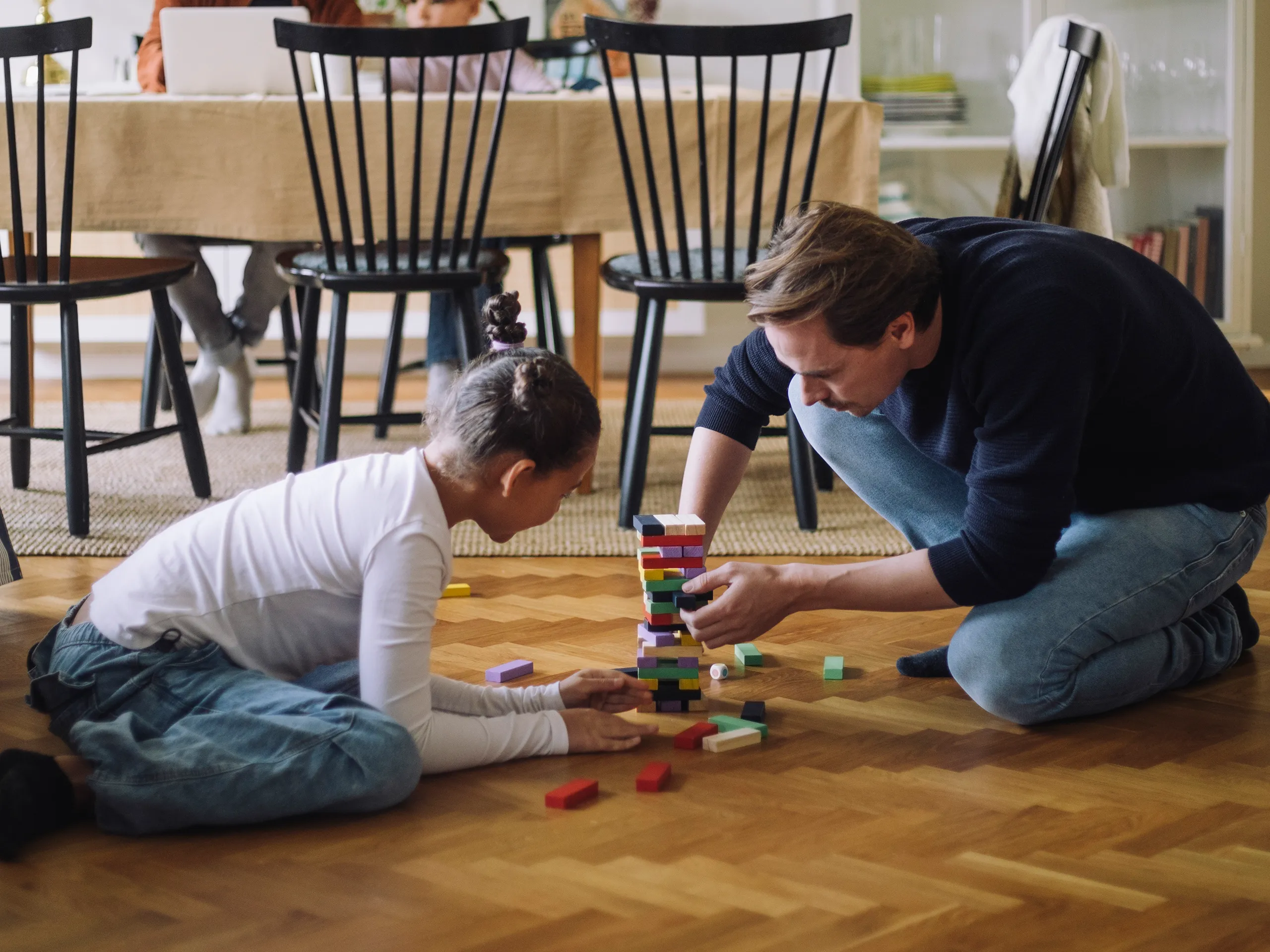 Vader en dochter bouwen samen een toren in de woonkamer