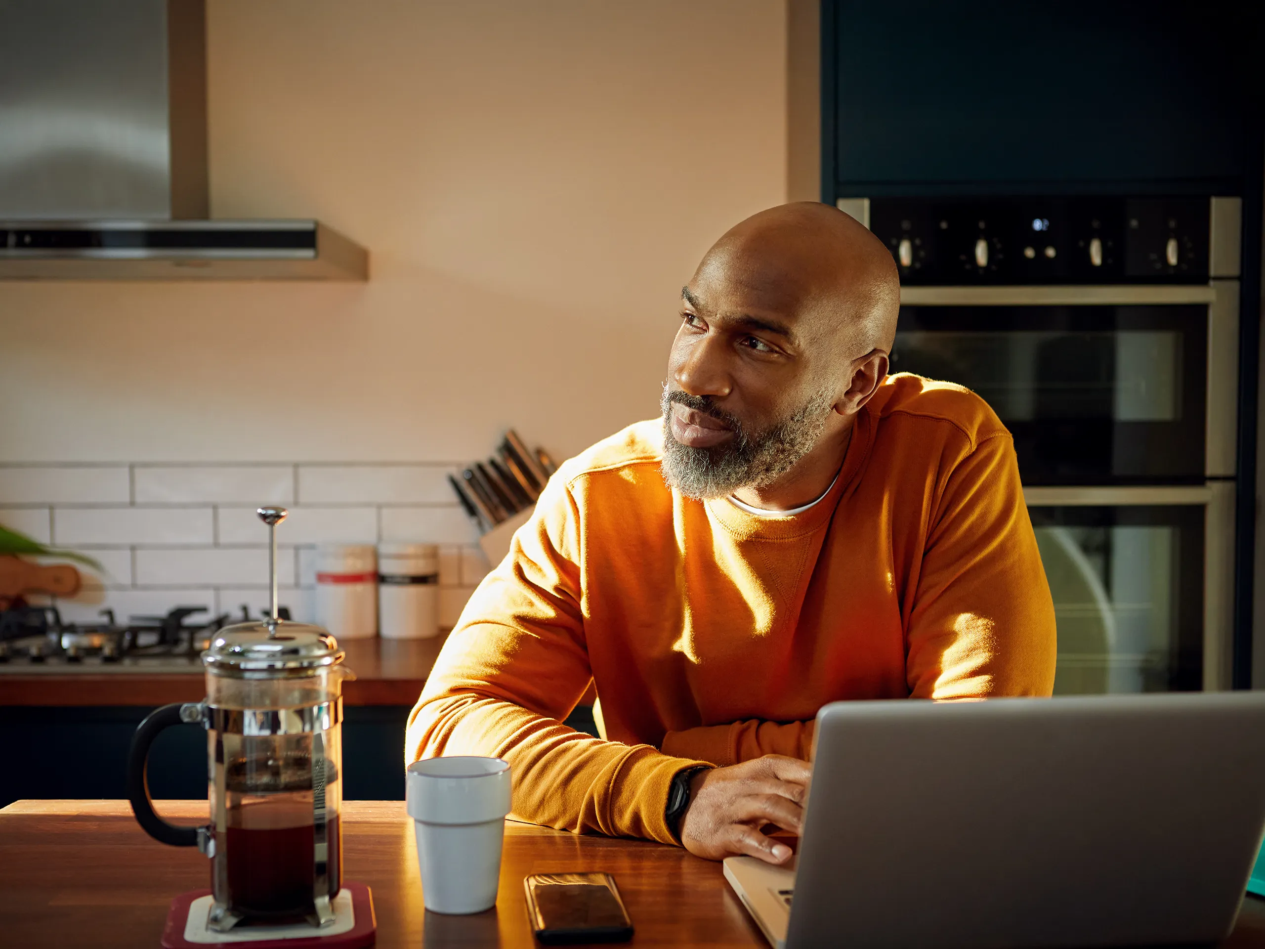 Man zit aan keukentafel en kijkt naar buiten