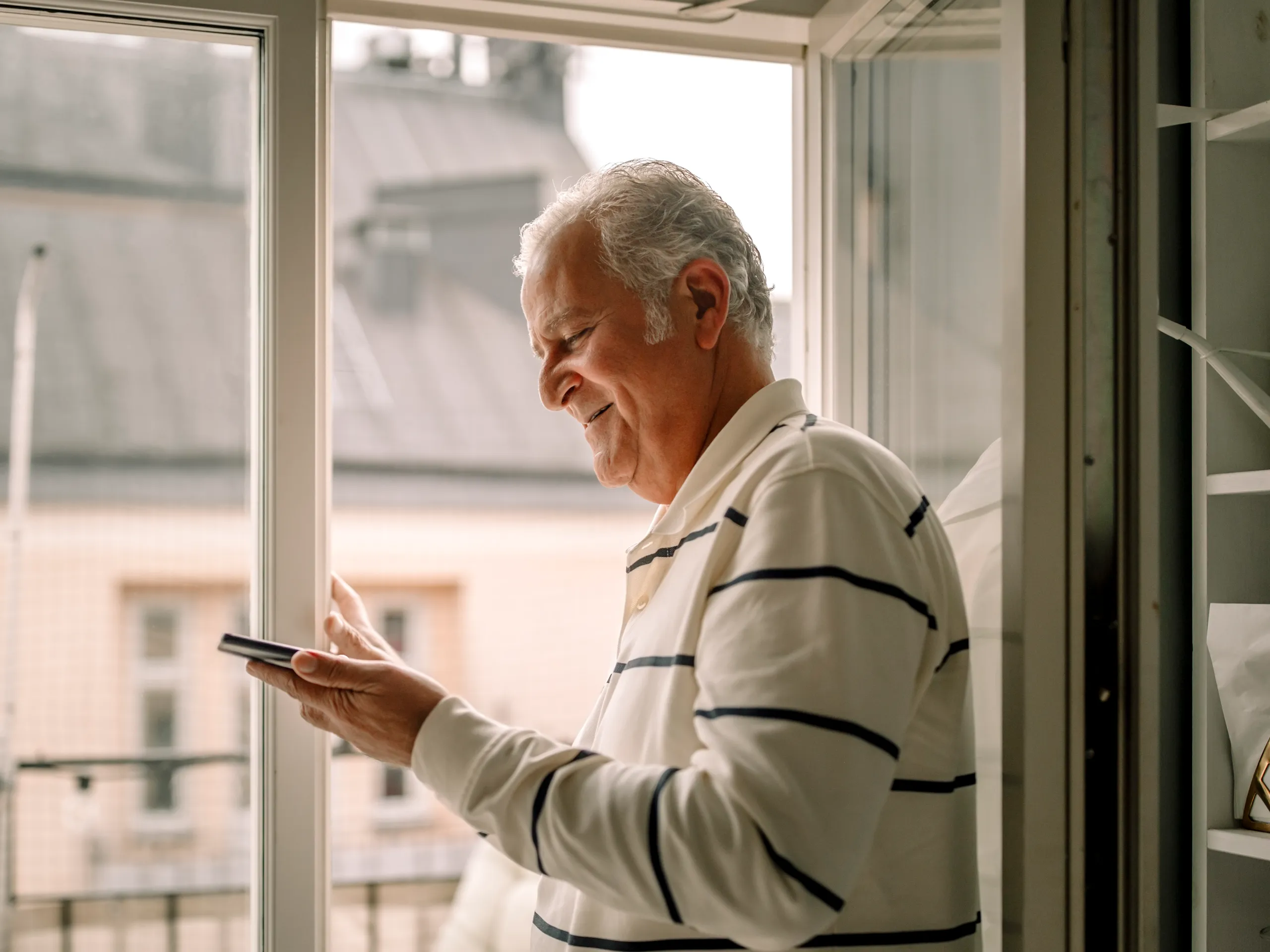 Man met smartphone in zonlicht