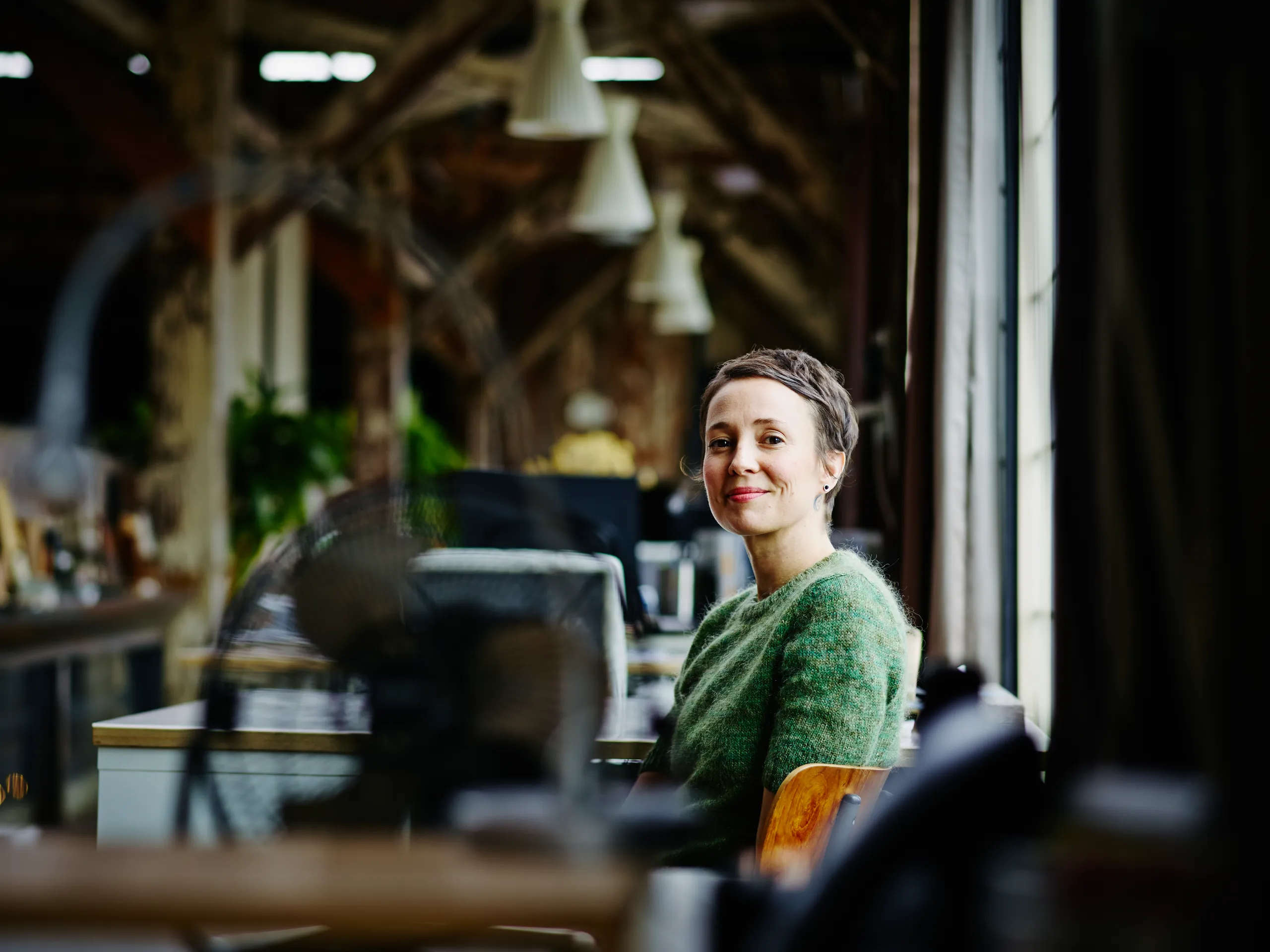 Lachende vrouw die bij een raam zit