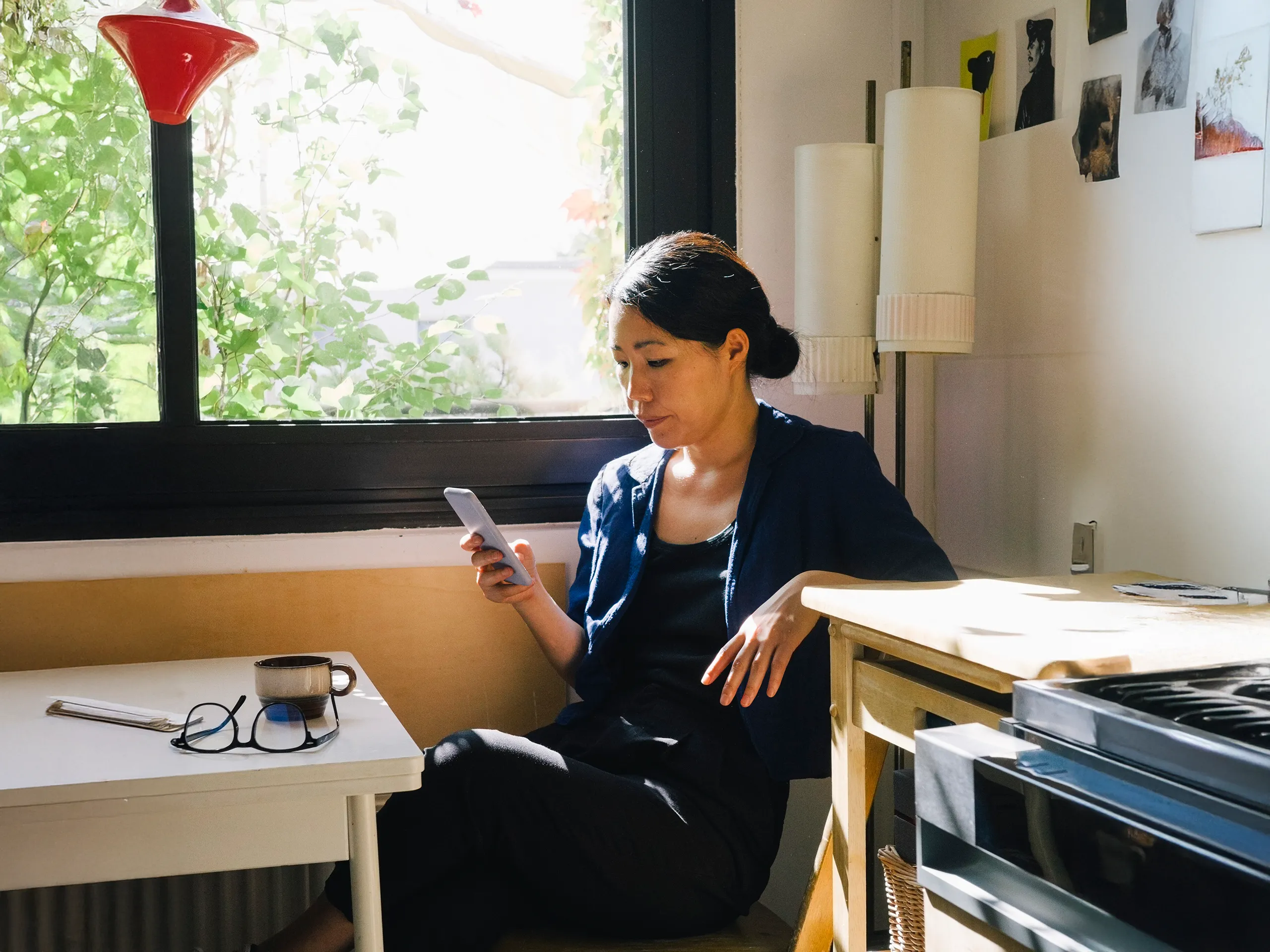 Vrouw zit in de zon met telefoon