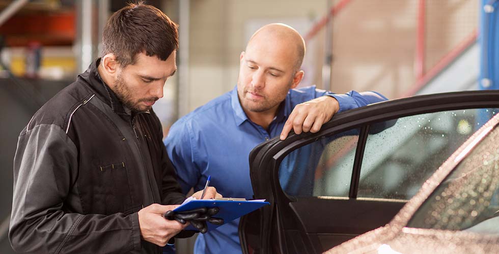 Man en monteur bij auto Juridische informatie over schade aan auto door wasstraat
