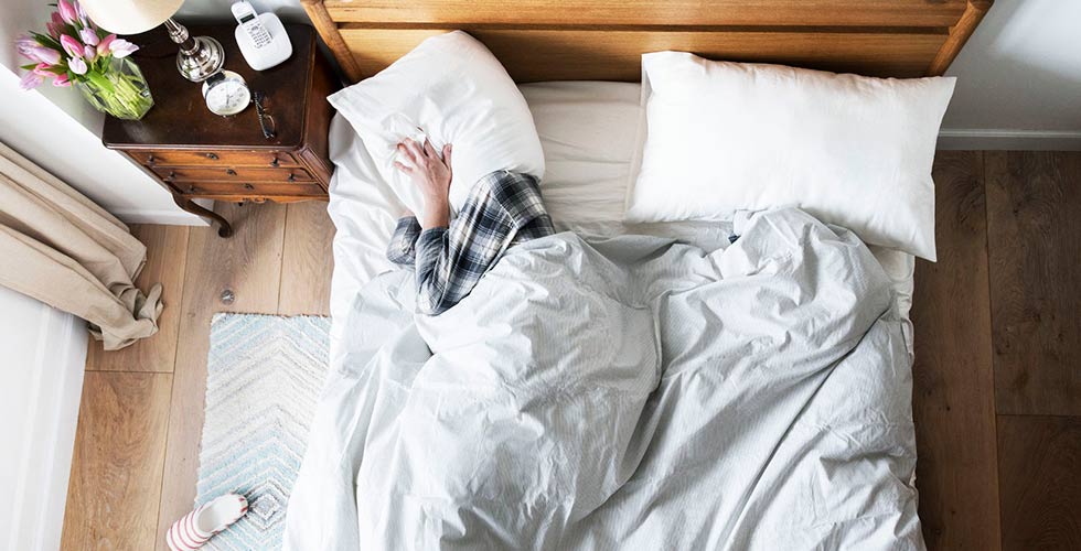 man-in-bed-met-kussen-over-hoofd-header