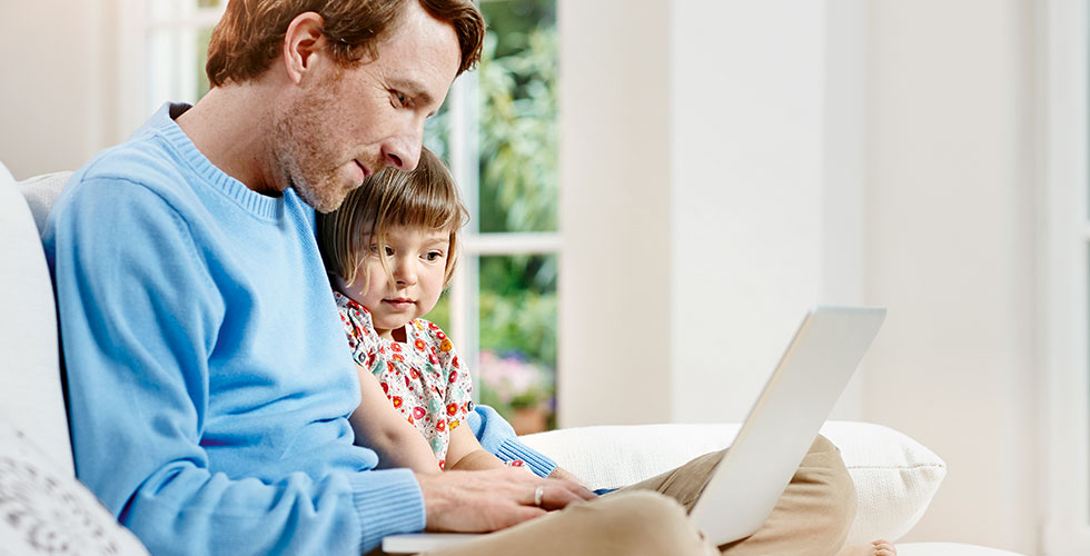 vader en dochter kijken naar laptop
