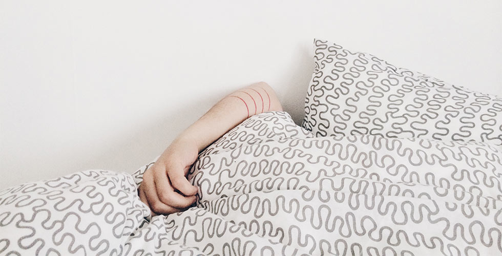 ziek in bed onder de dekens